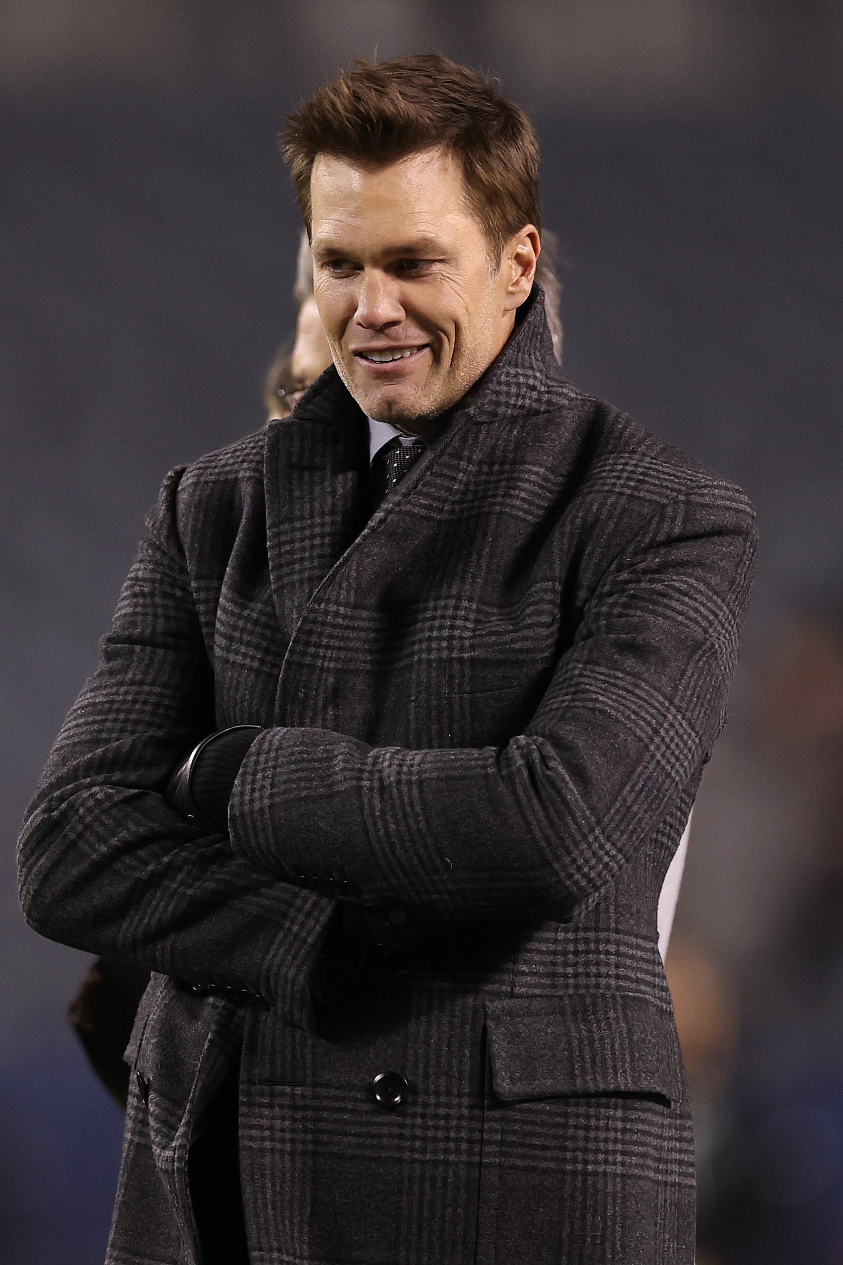Fox Sports commentator Tom Brady in a gray plaid overcoat.