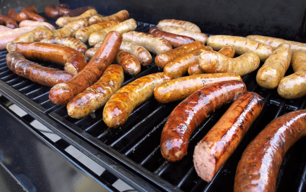Sausages and hot dogs cooking on a grill.
