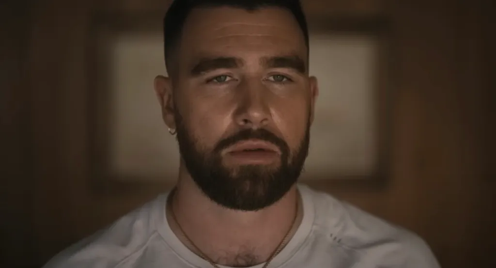 Travis Kelce with a beard and short hair.