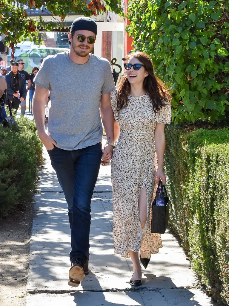 Garrett Hedlund and Emma Roberts walk hand-in-hand.