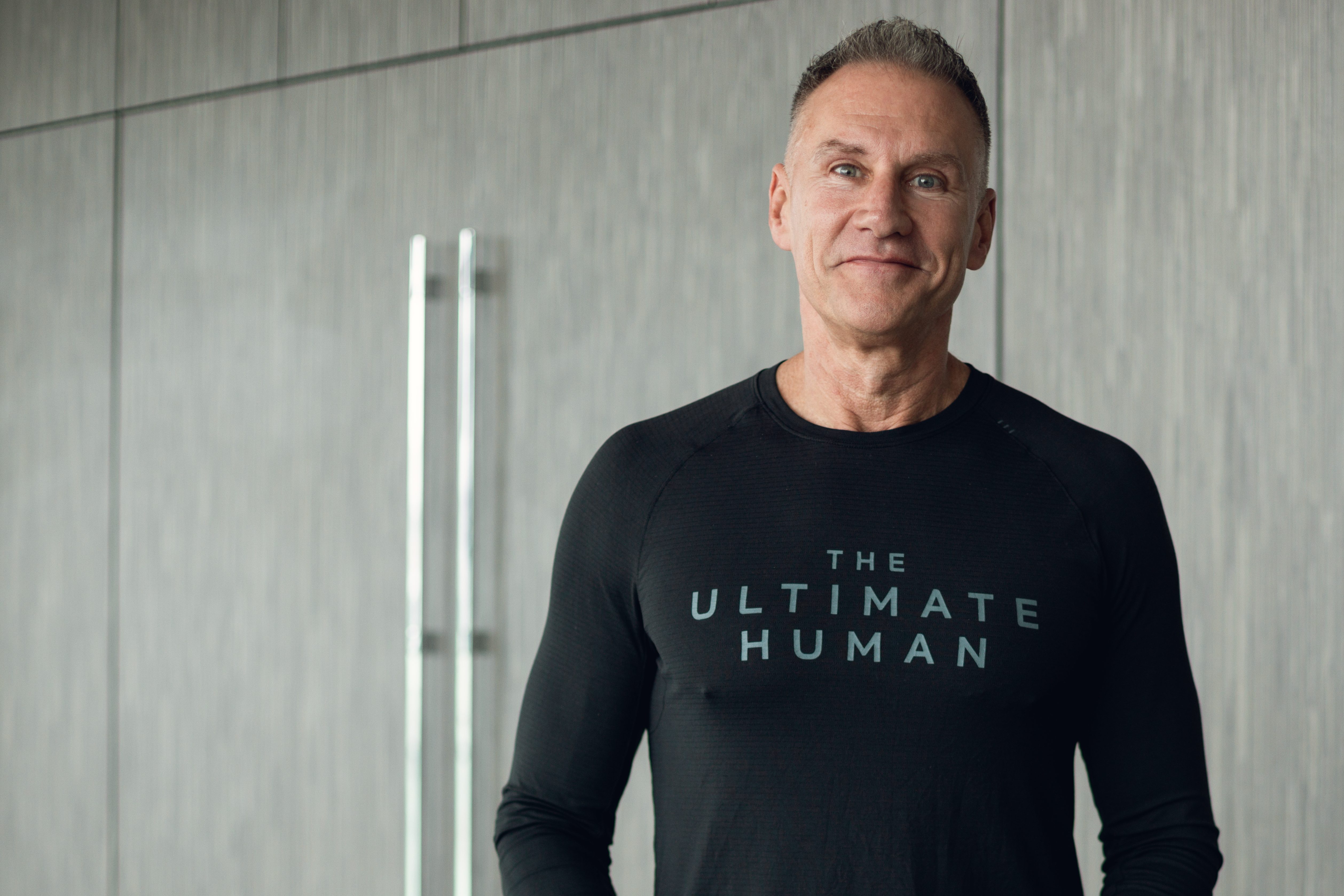Gary Brecka standing behind a counter with various supplements.