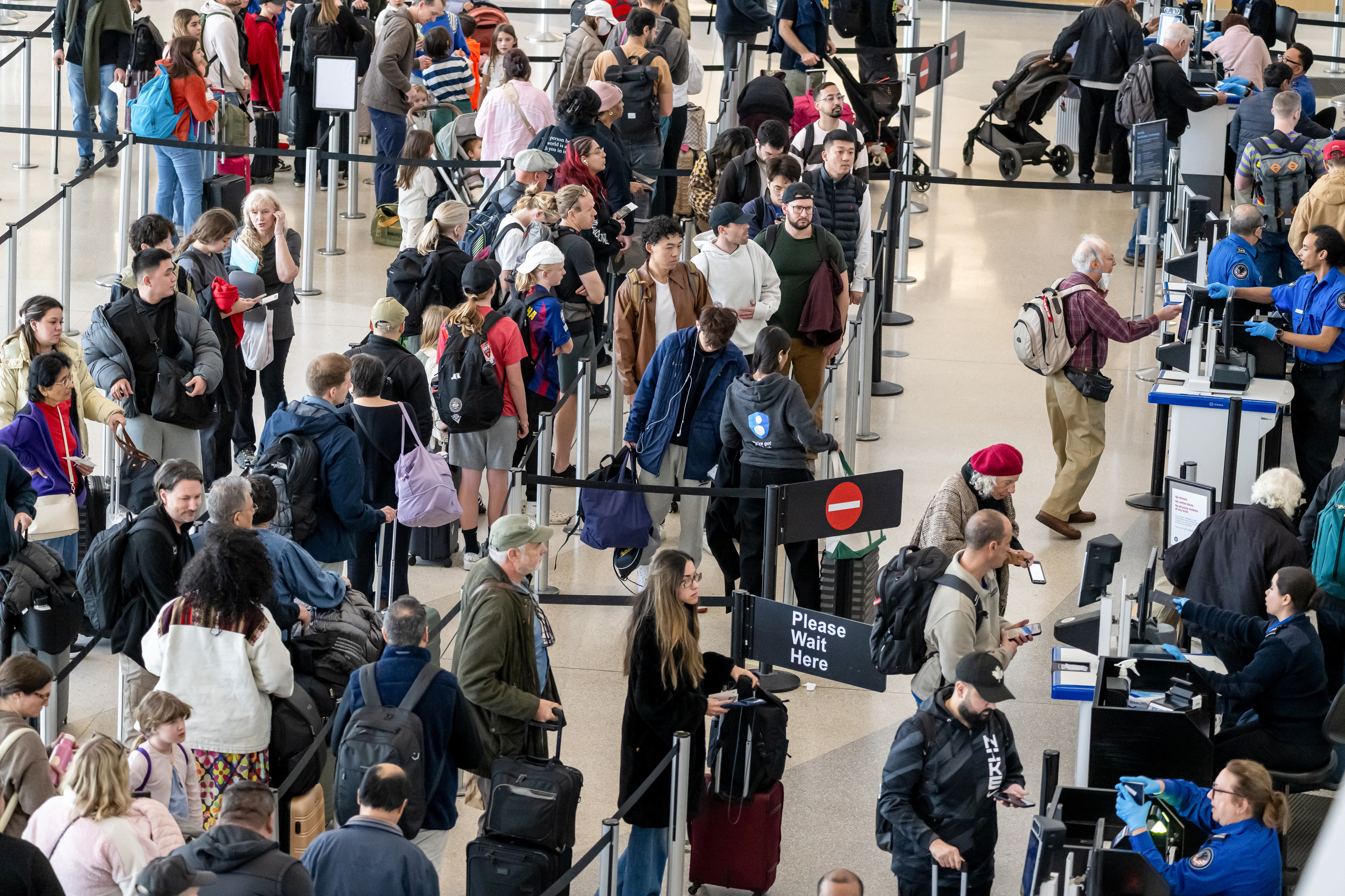 A security line is filled with passengers. A security line is filled with passengers.
