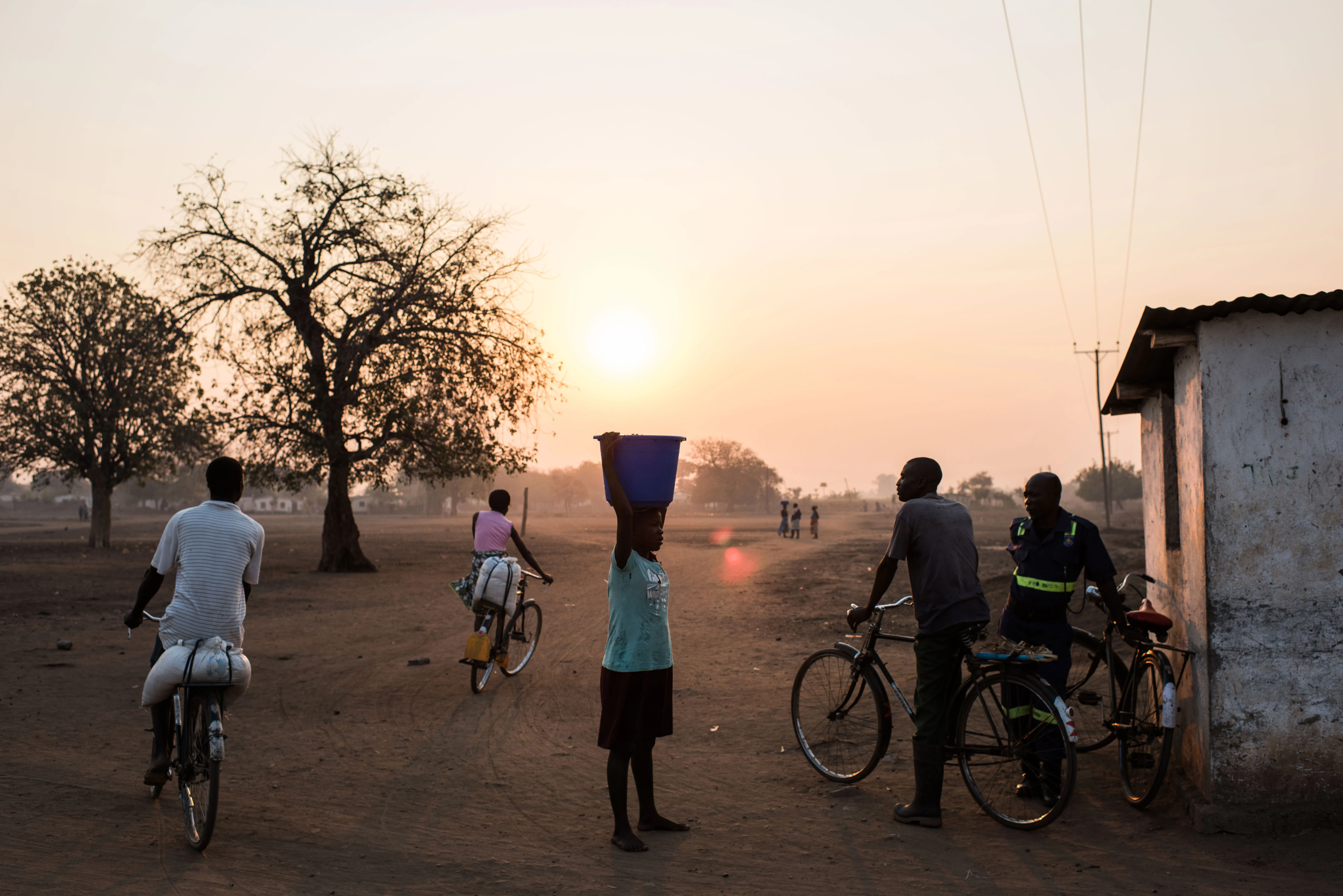 A group of rural Malawians stand in a village that is vulnerable to drought.