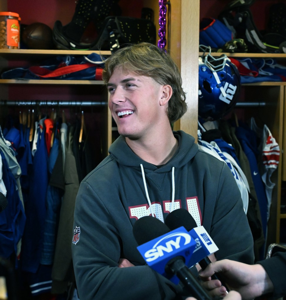 Giants quarterback Jaxson Dart speaks to the media in a locker room.