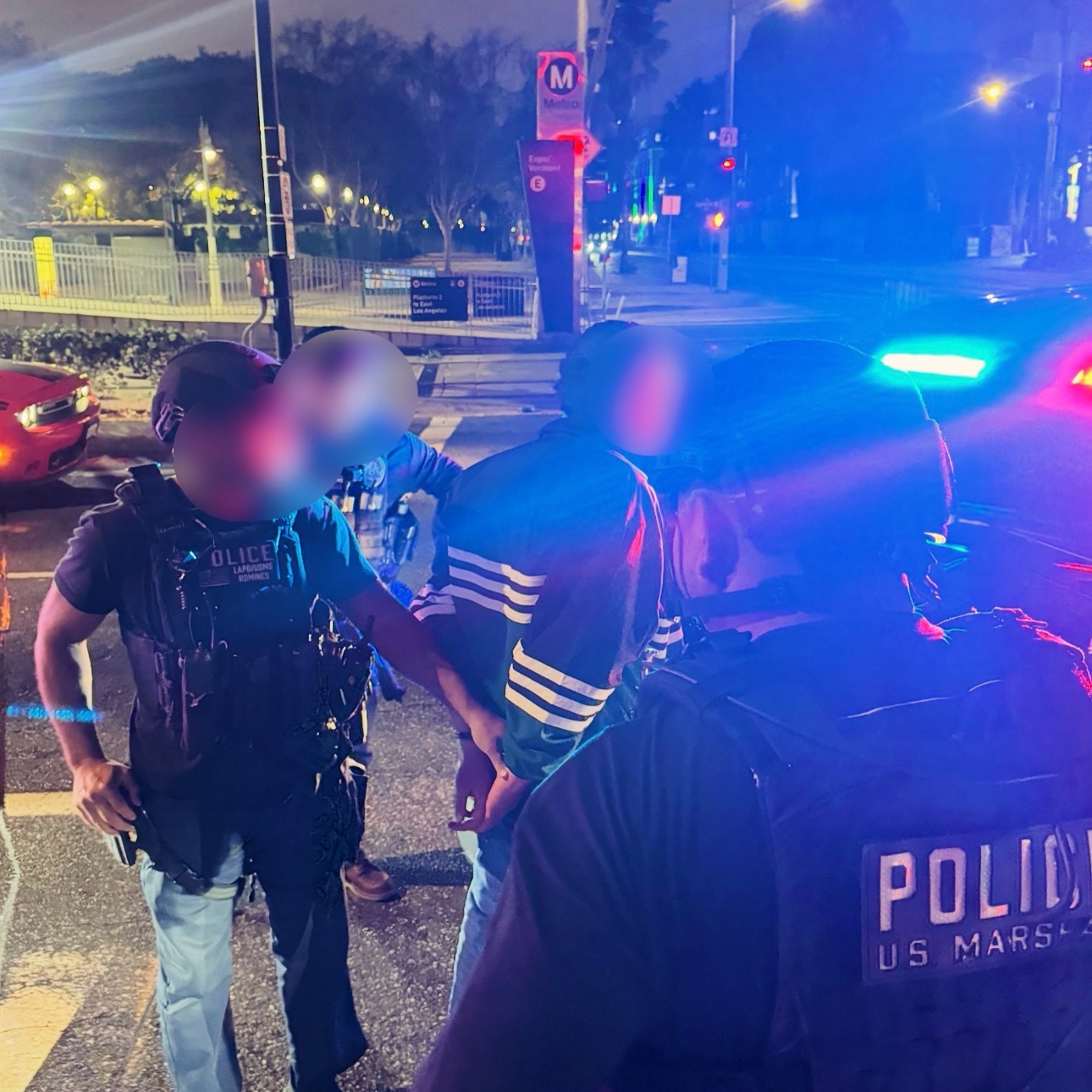 Police arresting a suspect at night, with two officers in the foreground and a blurred background featuring a Metro station sign.