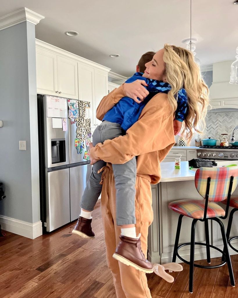 Meghan King holds one of her children in a kitchen.