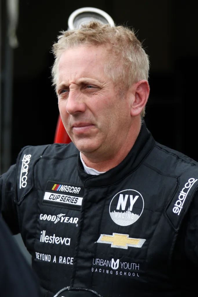 Greg Biffle in a black NASCAR Cup Series racing suit.