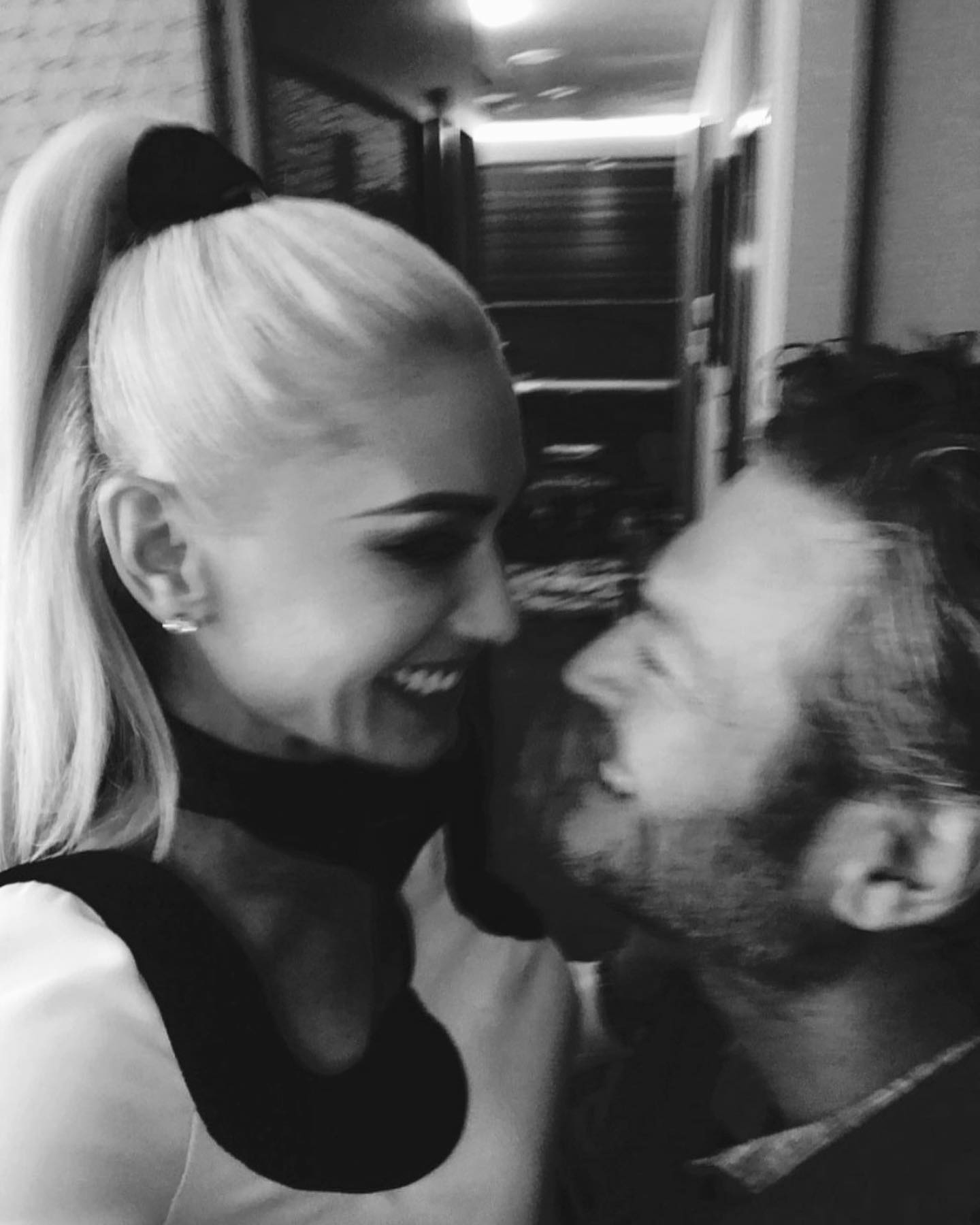 Gwen Stefani and Blake Shelton looking at each other and smiling.