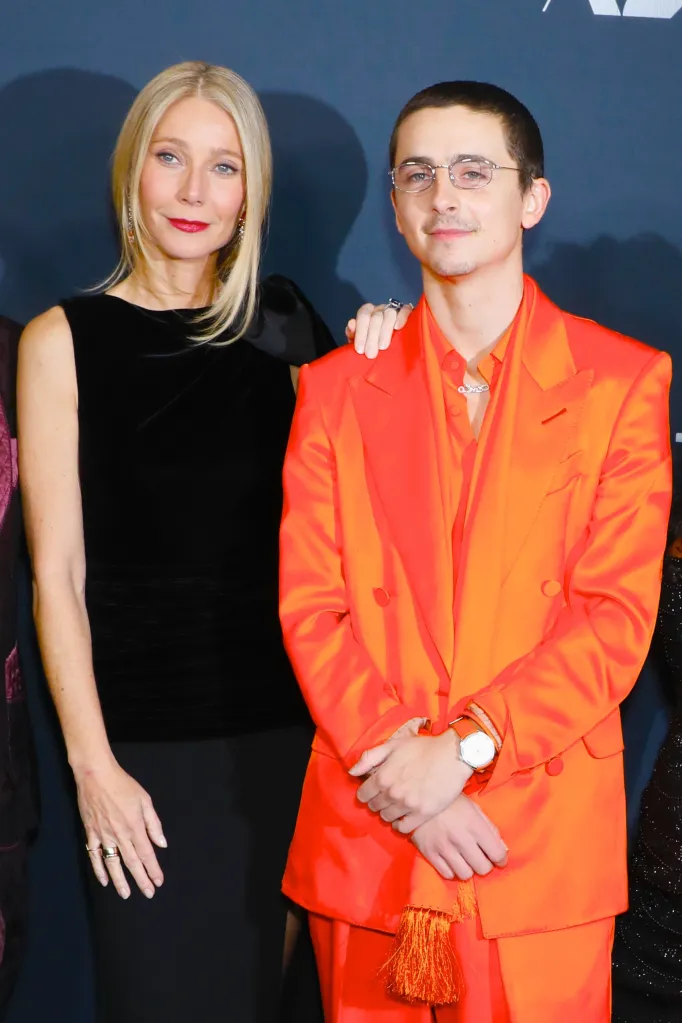 Gwyneth Paltrow in a black dress and Timothée Chalamet in an orange suit at A24's 'Marty Supreme' premiere.