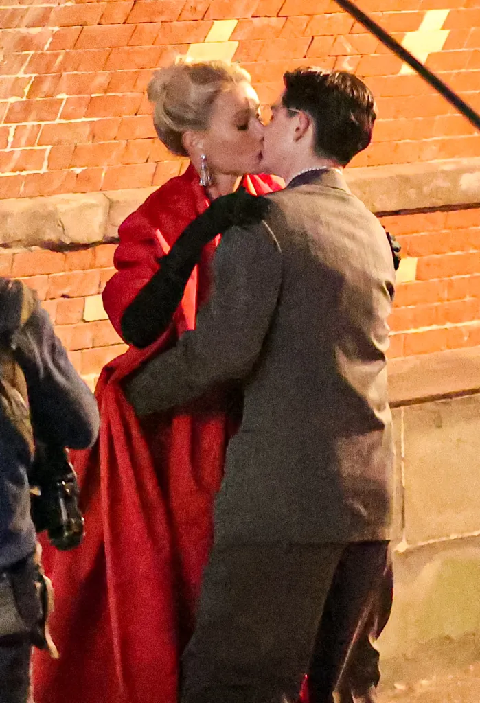 Gwyneth Paltrow in a red coat and Timothée Chalamet in a dark suit kissing on the 