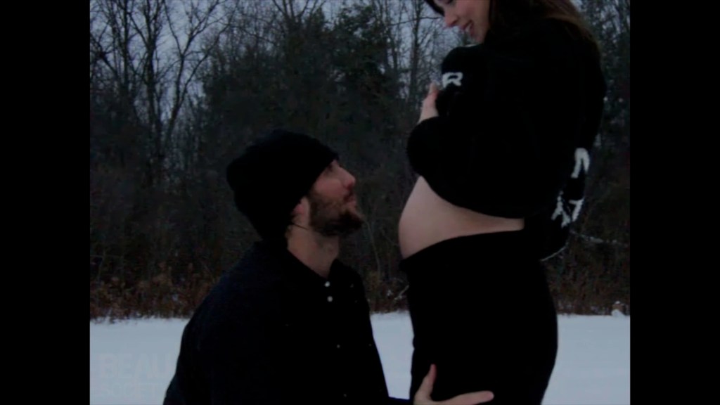 Hailee Steinfeld and Josh Allen in the snow with Steinfeld's bare baby bump showing.