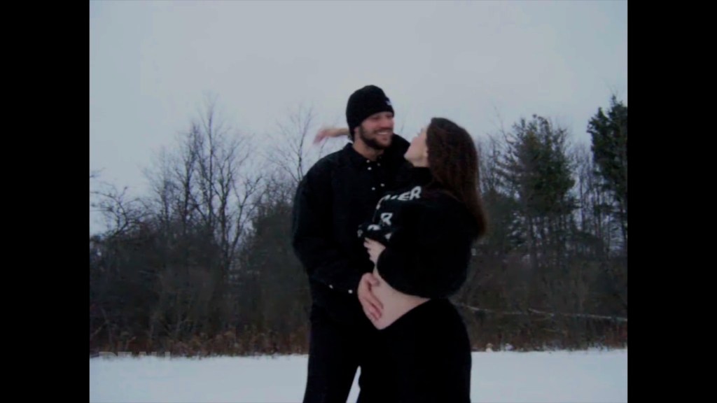 Hailee Steinfeld and Josh Allen in the snow with Steinfeld cradling her pregnant belly.