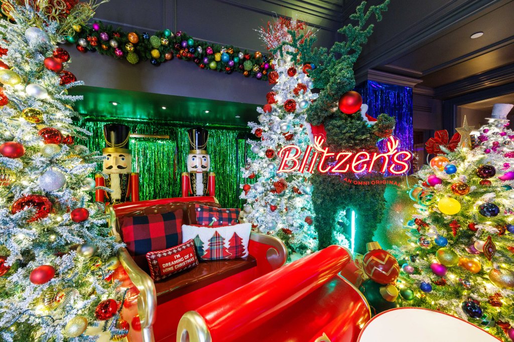 Blitzen's Bar at Omni Berkshire Place is decorated for Christmas with multiple trees, nutcrackers, and a sleigh.