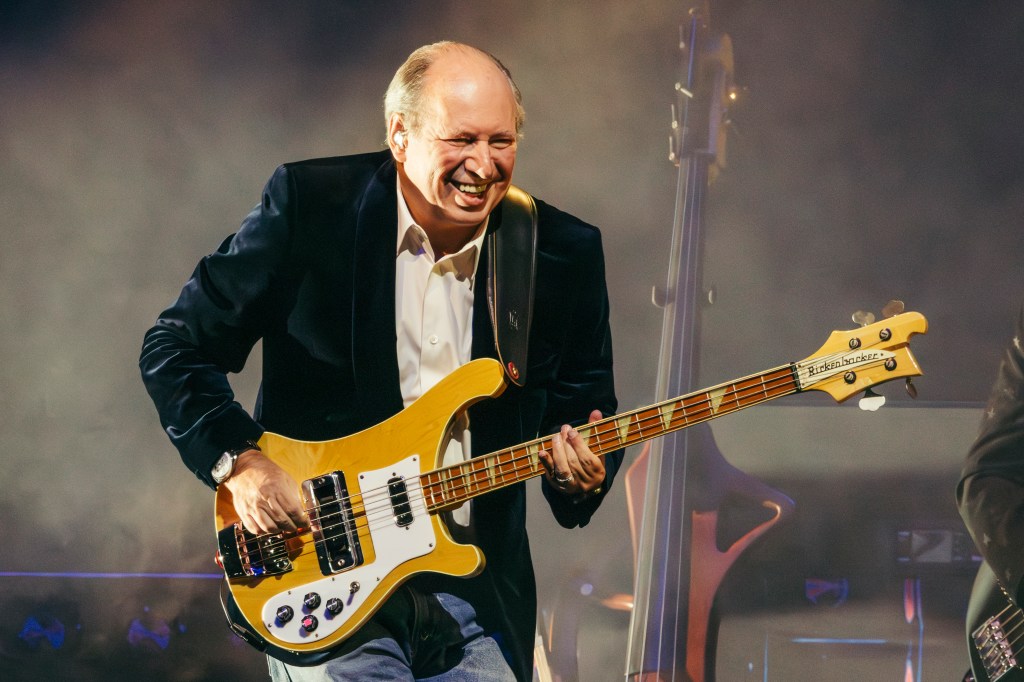 Hans Zimmer performing live on stage playing a Rickenbacker bass.