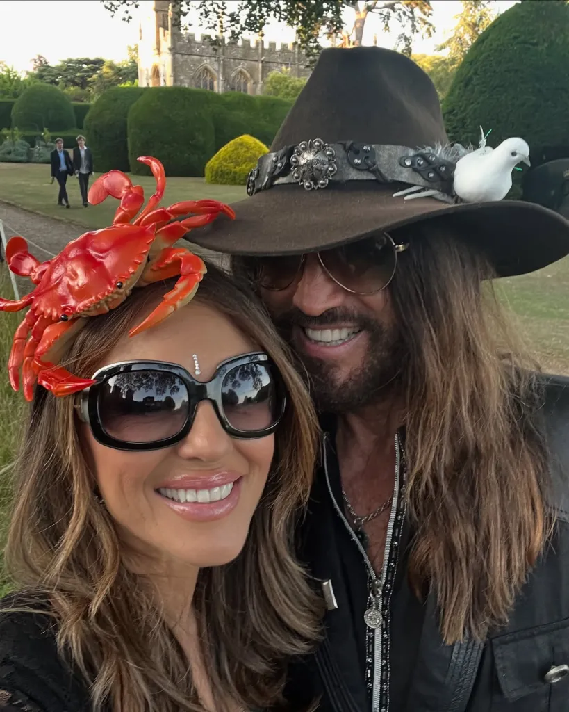 Elizabeth Hurley wearing a crab headpiece and Billy Ray Cyrus in a cowboy hat with a dove on it.