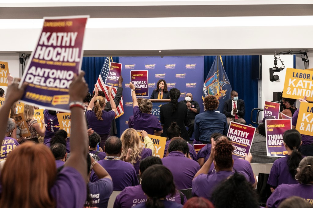 Governor Kathy Hochul speaks at 1199 SEIU Headquarters while attendees hold up signs endorsing Democrats for statewide offices.