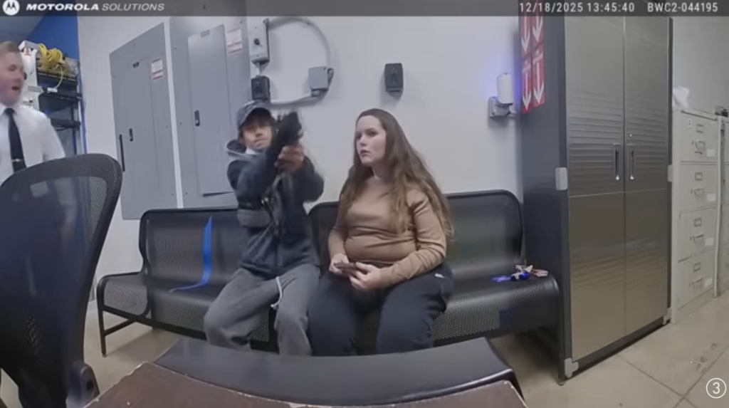 Newman aims a gun at a Canton Police Officer inside the Walmart security office.