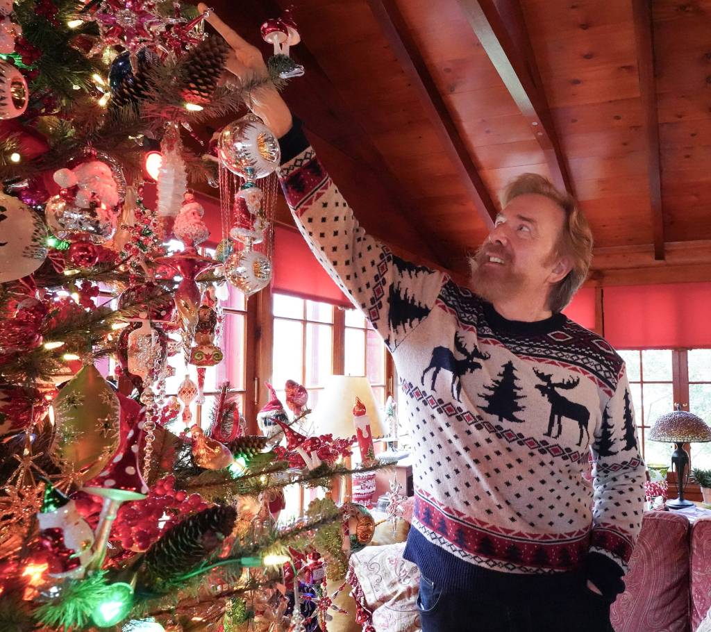 Christopher Radko, an ornament designer, decorating a Christmas tree.