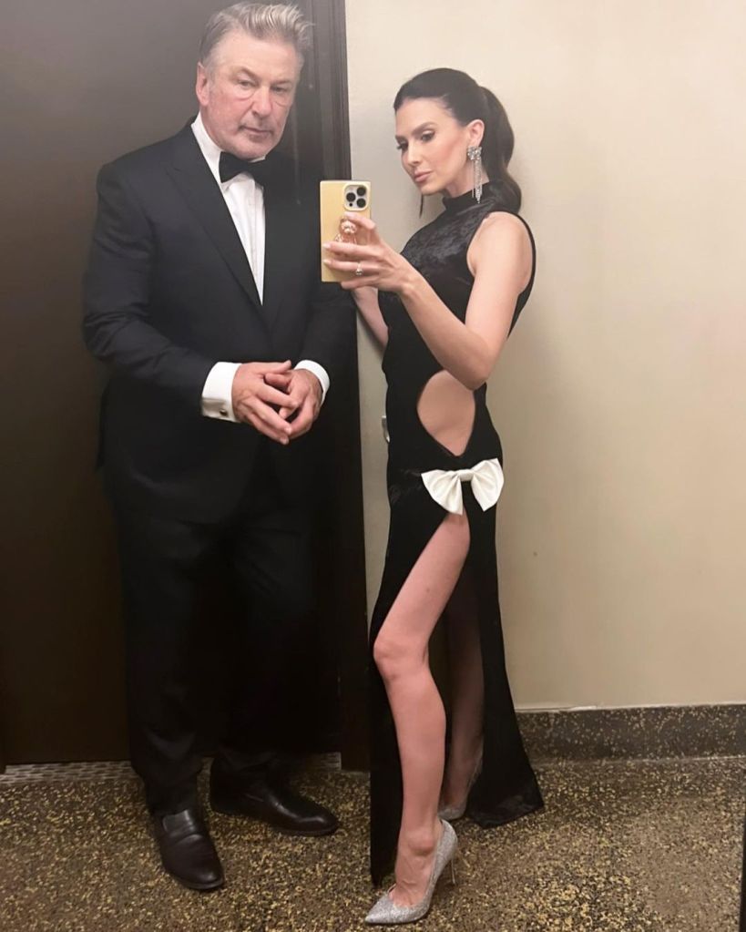Hilaria Baldwin taking a mirror selfie with Alec Baldwin, both dressed formally.