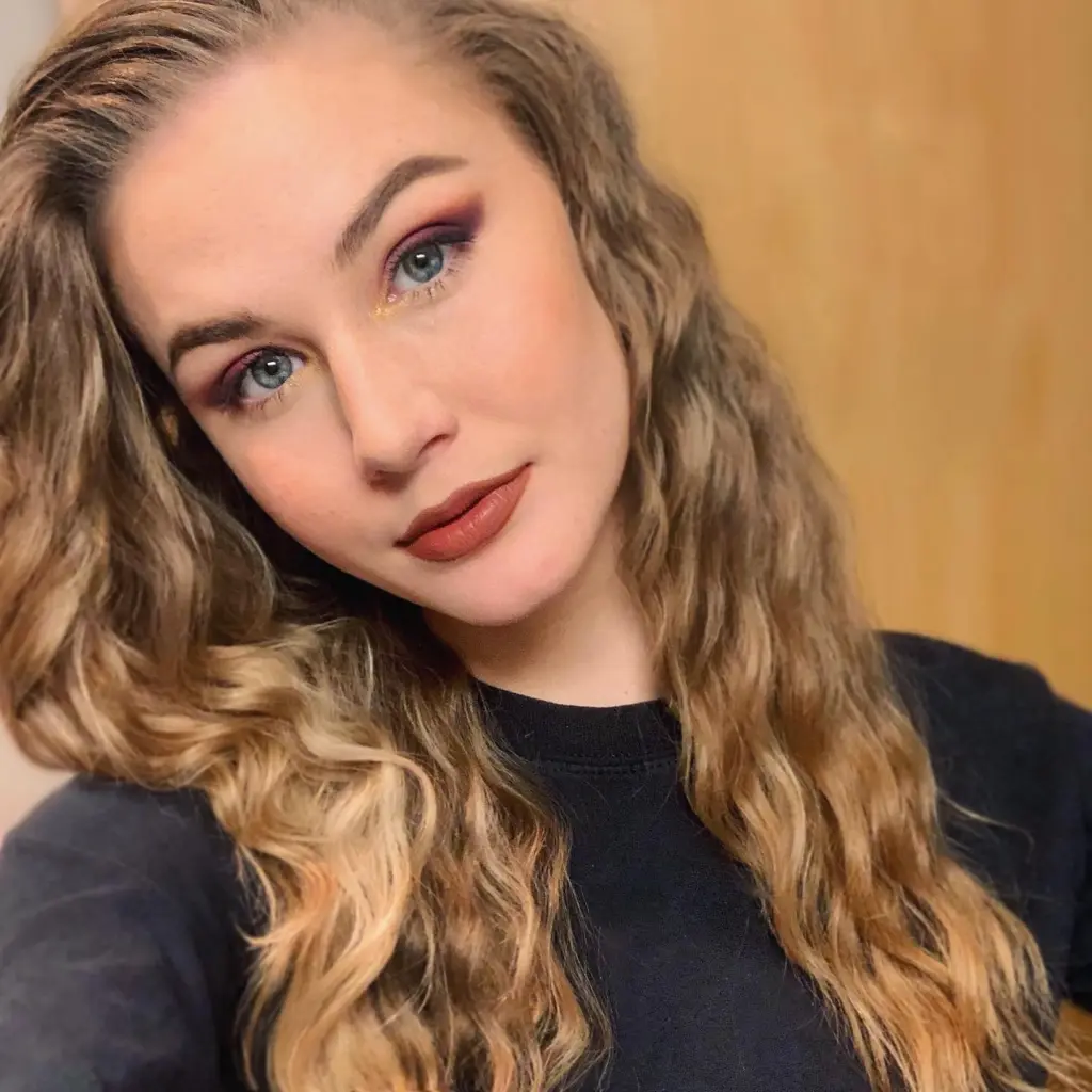 Johnnie Faye Cartwright with wavy blonde hair, blue eyes, and red eyeshadow.