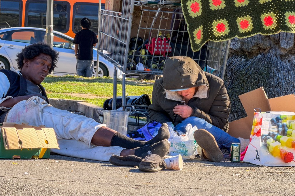 Two homeless people resting at MacArthur Park in Los Angeles.