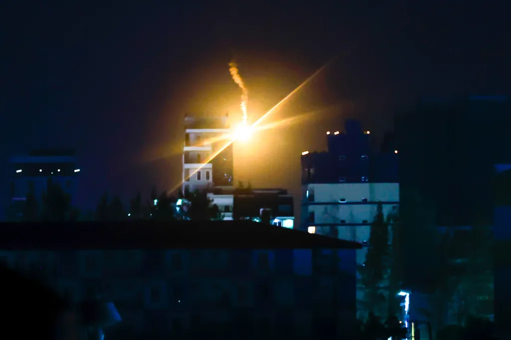Illumination flares fired by Thai military forces shine over buildings in Poipet, Cambodia, as seen from Sa Kaeo, Thailand.