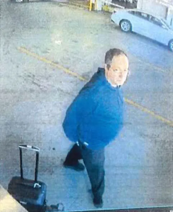 Surveillance image of Claudio Neves Valente, a suspect in the mass shooting at Brown University, next to a black suitcase.