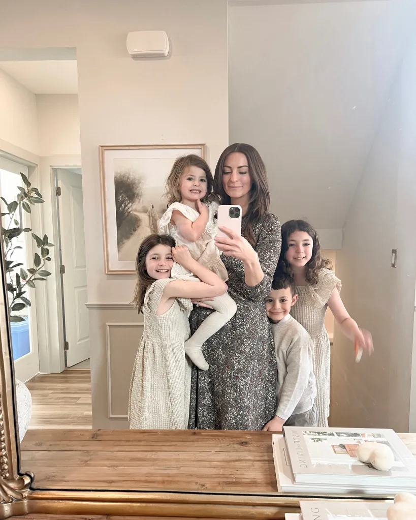Influencer Melissa Mae Carlton taking a mirror selfie with her four children.