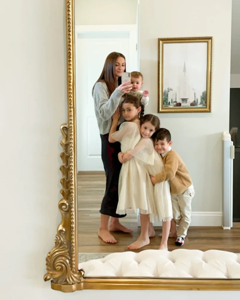 Influencer Melissa Mae Carlton taking a mirror selfie with her four children.