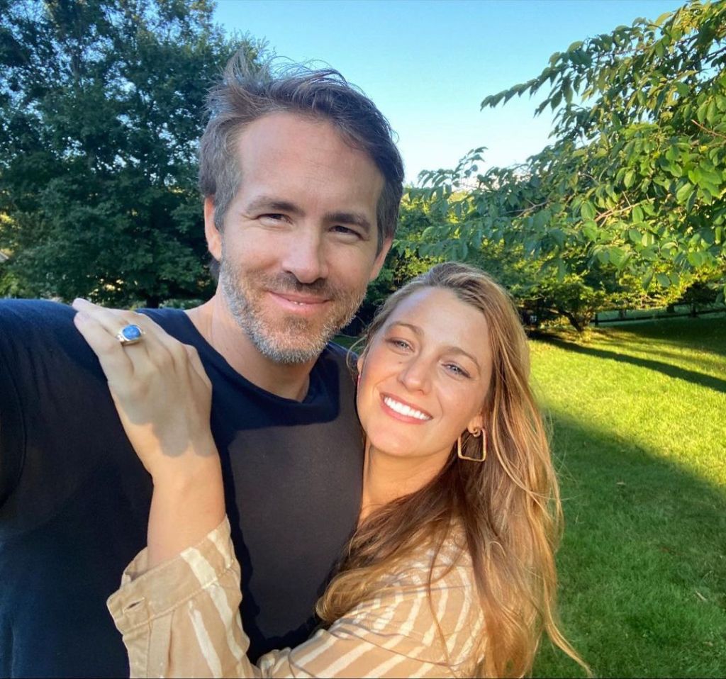 Ryan Reynolds and Blake Lively smiling and embracing outdoors.