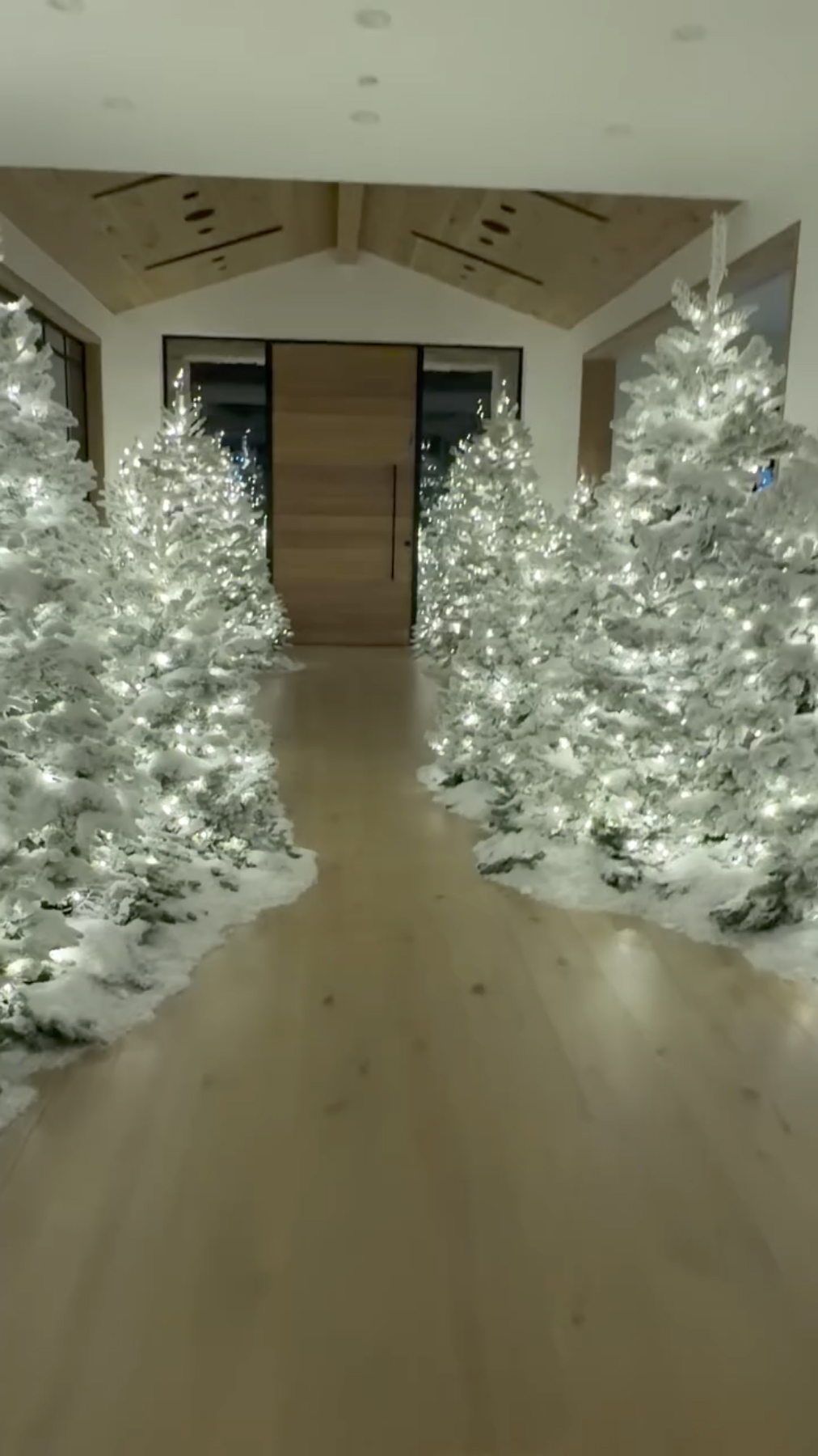 Kim Kardashian's hallway filled with dozens of illuminated, snow-covered Christmas trees.