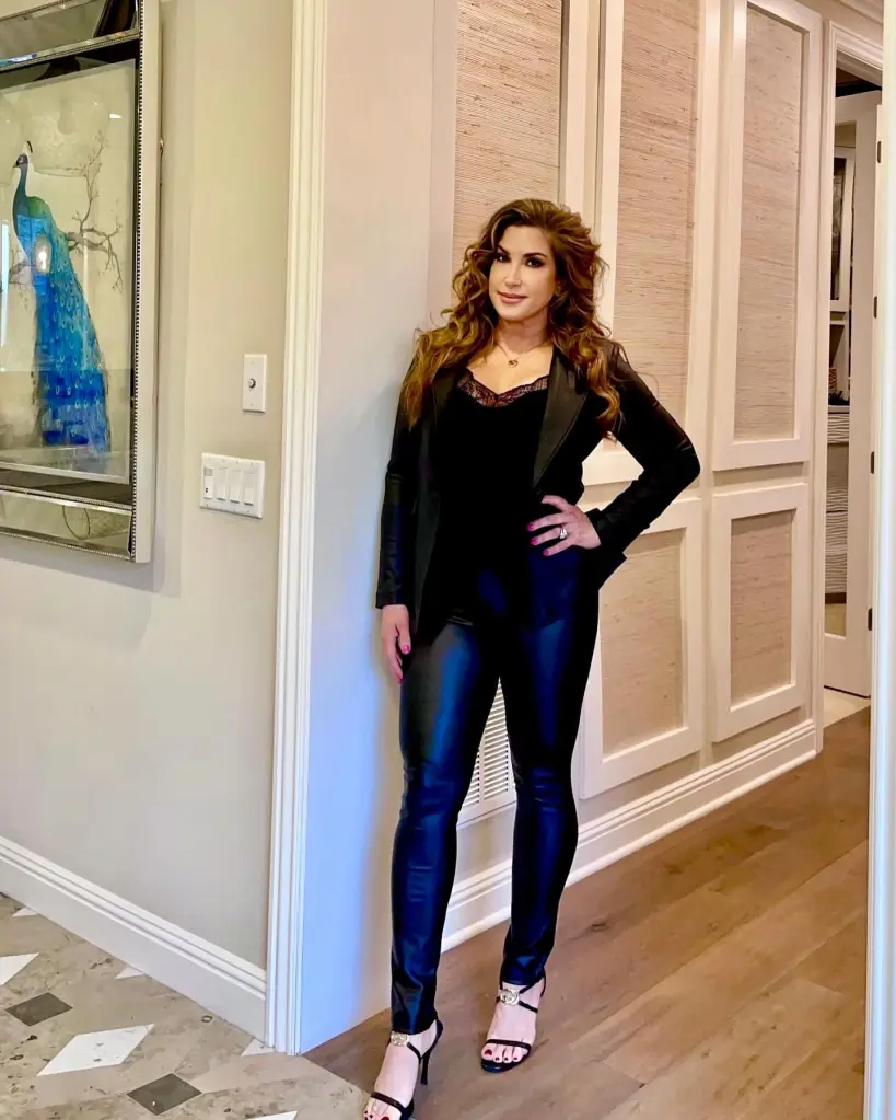 Jacqueline Laurita in a black outfit, including a jacket, tank top, and pants.