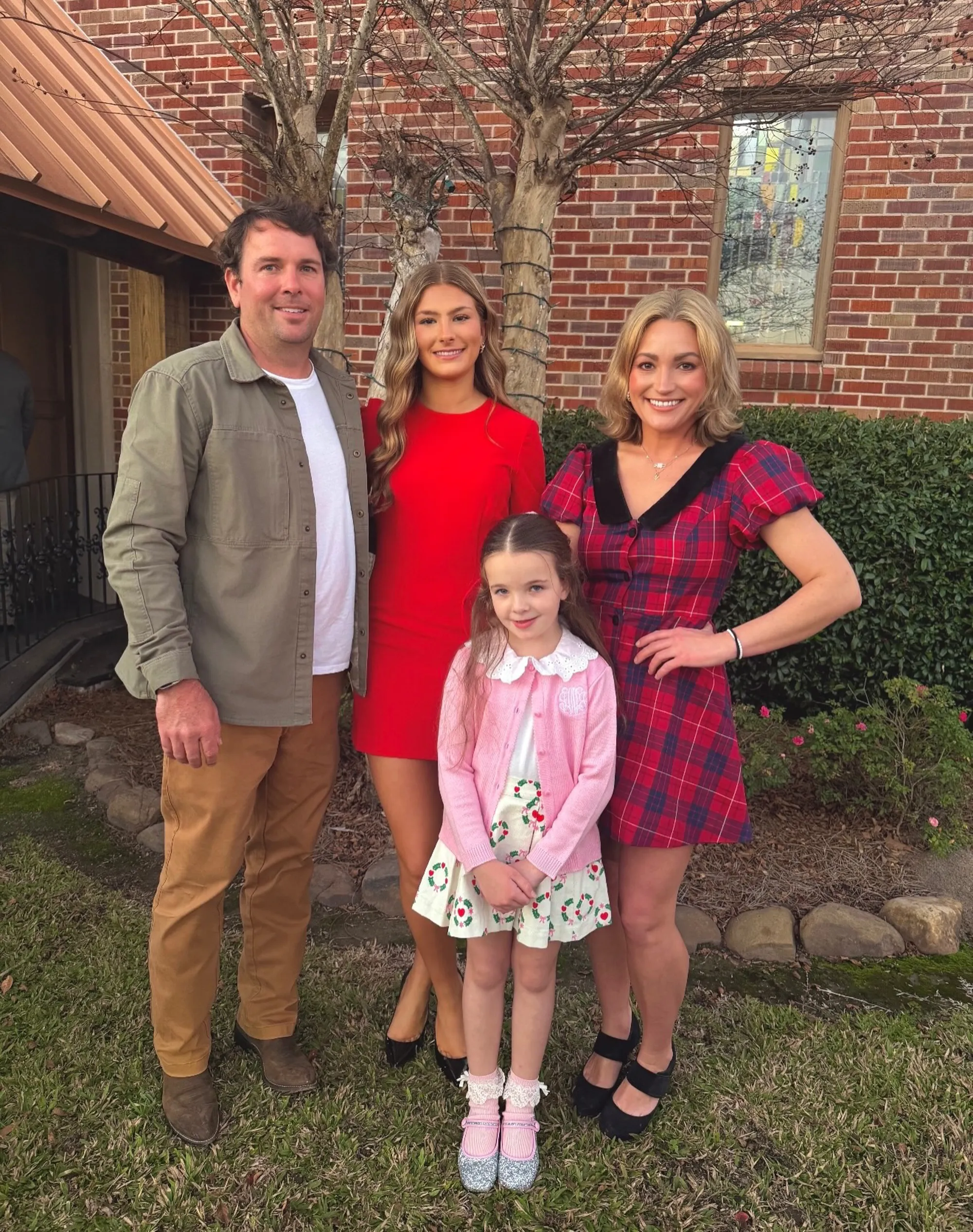 Jamie Lynn Spears, her husband, and two daughters stand in front of a brick building.