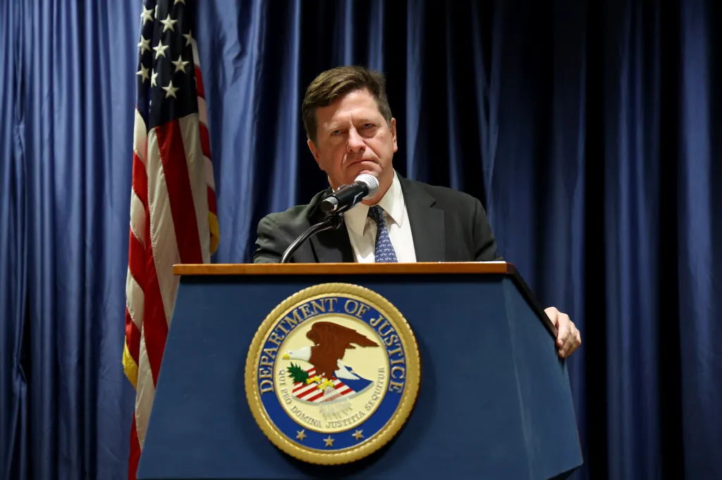 Jay Clayton, U.S. Attorney for the Southern District of New York, speaking at a podium with the Department of Justice seal.