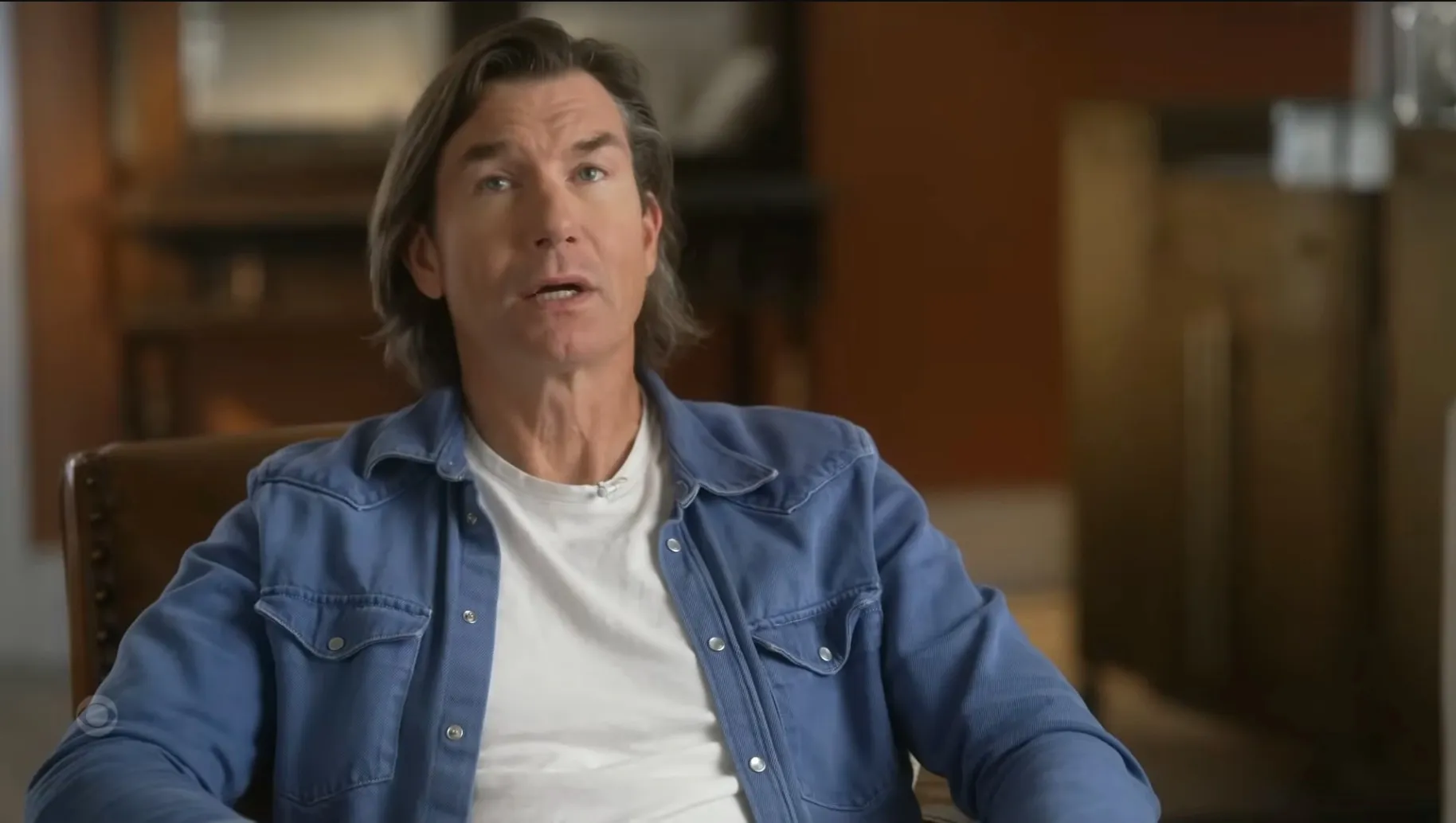 Jerry O'Connell speaking in a blue shirt with a white t-shirt underneath.