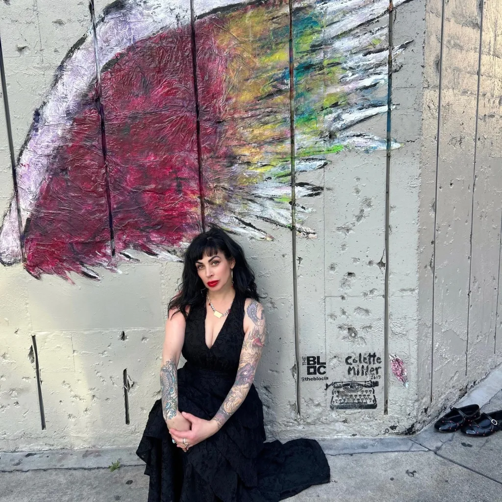 Jillian Lauren Shriner posing in front of a colorful mural.
