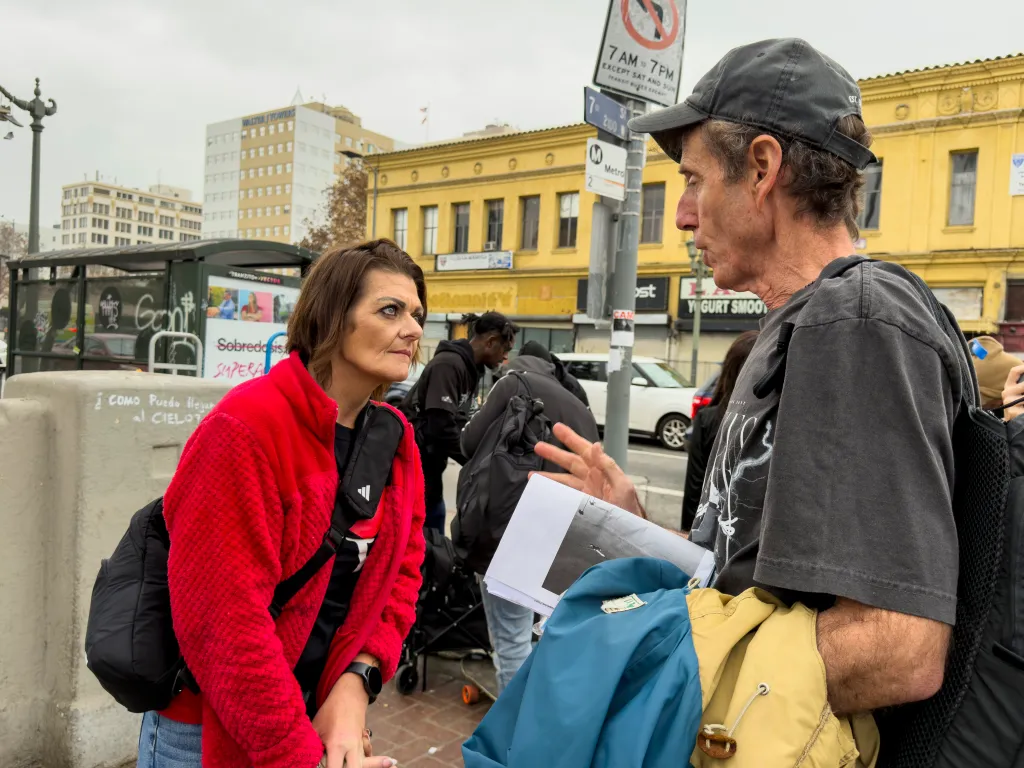 John Alle talks with a homeless woman at MacArthur Park in Los Angeles.