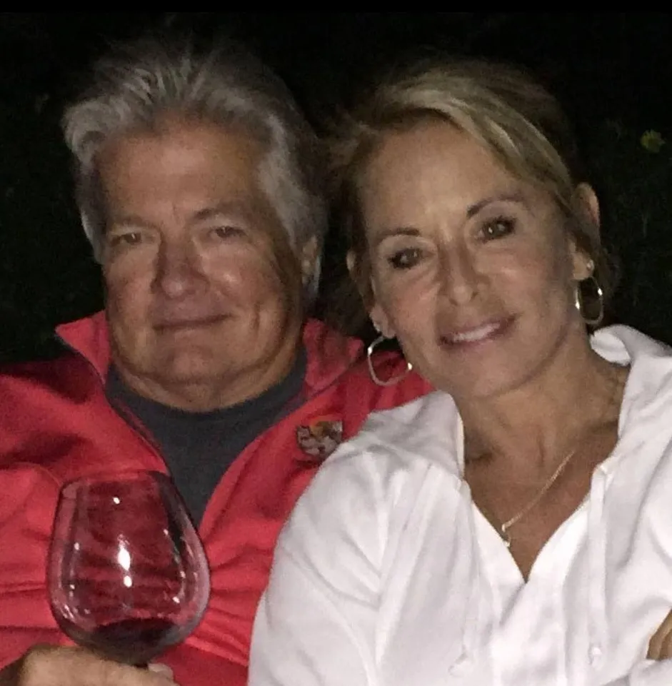 John Jay Hoff holding a glass of red wine, and Kathleen Ocorr Hoff posing together.