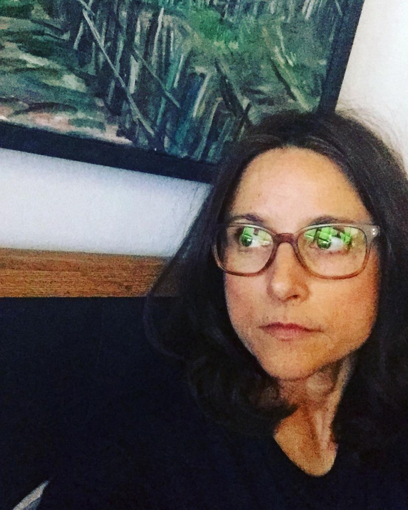 Julia Louis-Dreyfus in glasses looking off to the right.