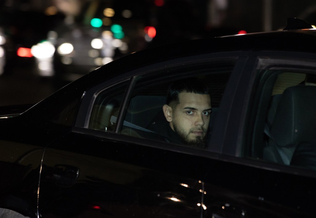 Justin Aguilera sitting in the back of an unmarked police car.