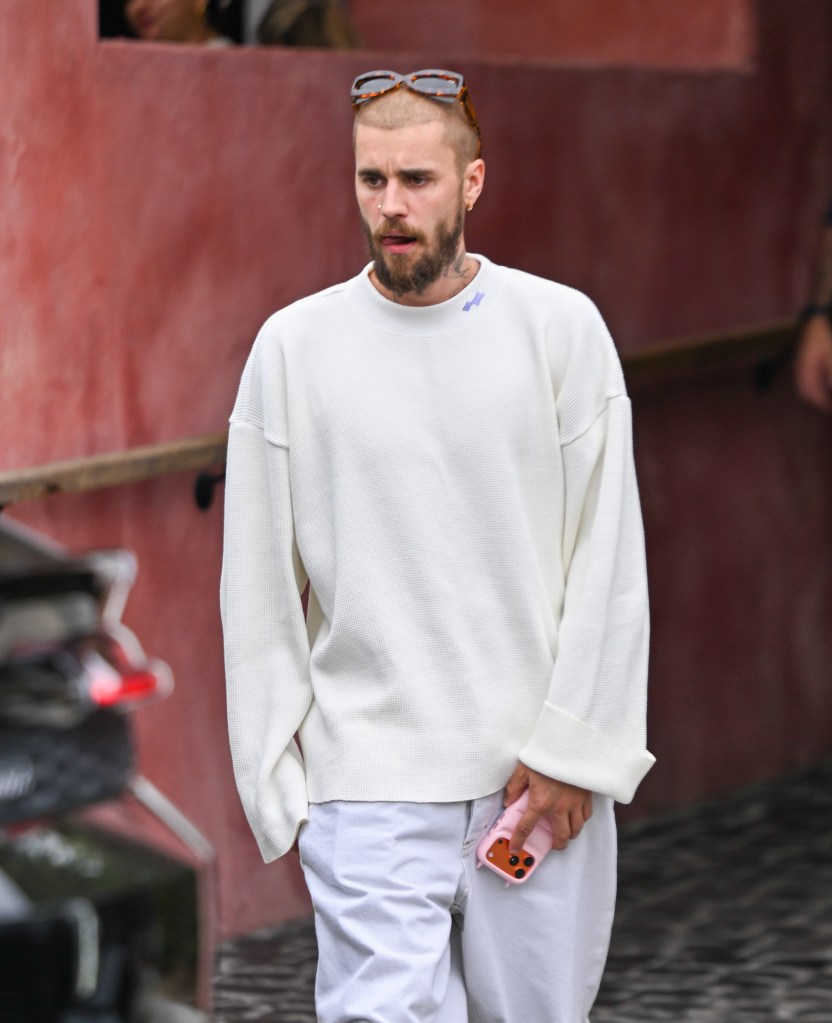 Justin Bieber in Los Angeles, wearing a white shirt and holding a pink phone.