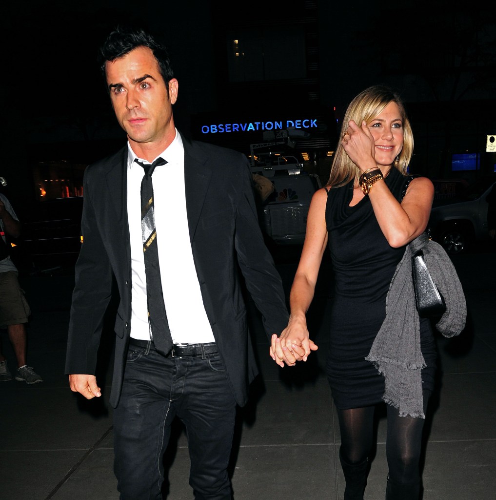 Justin Theroux and Jennifer Aniston holding hands at Christie's in New York City.