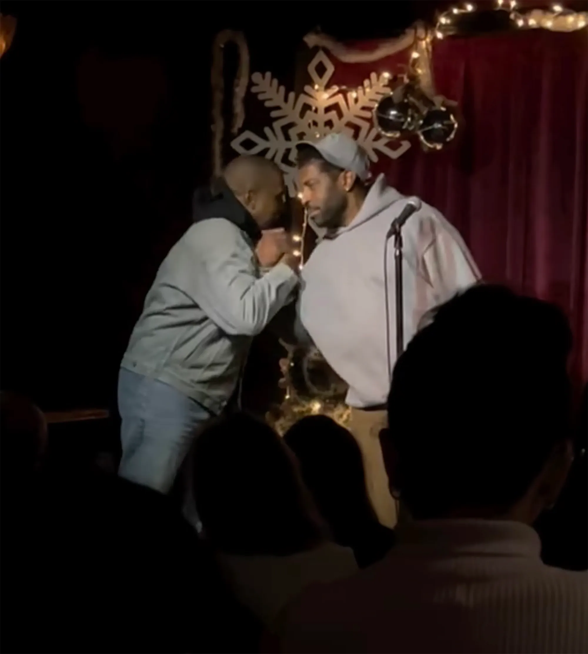Kanye West and Deon Cole face each other onstage.