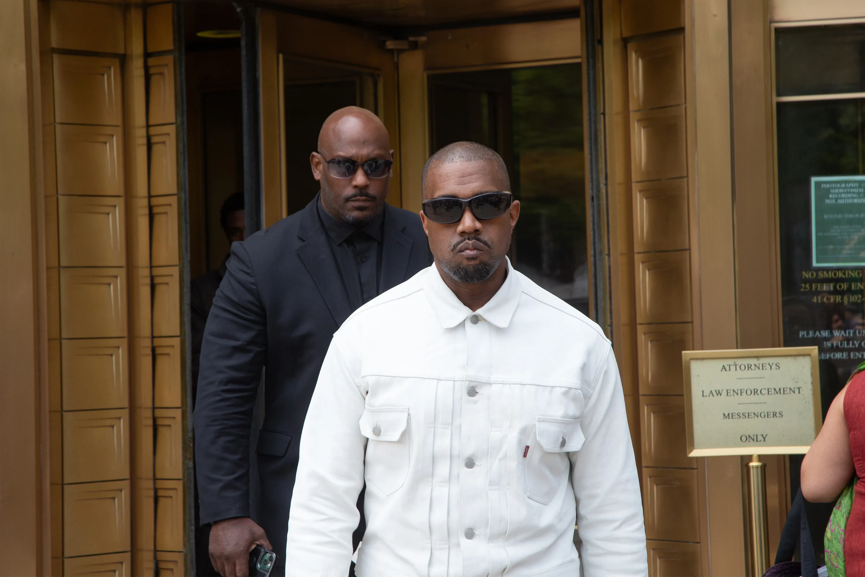 Kanye West and a bodyguard leaving the Diddy trial.