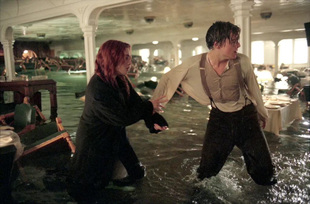 Kate Winslet and Leonardo DiCaprio wading through knee-deep water in a sinking room.