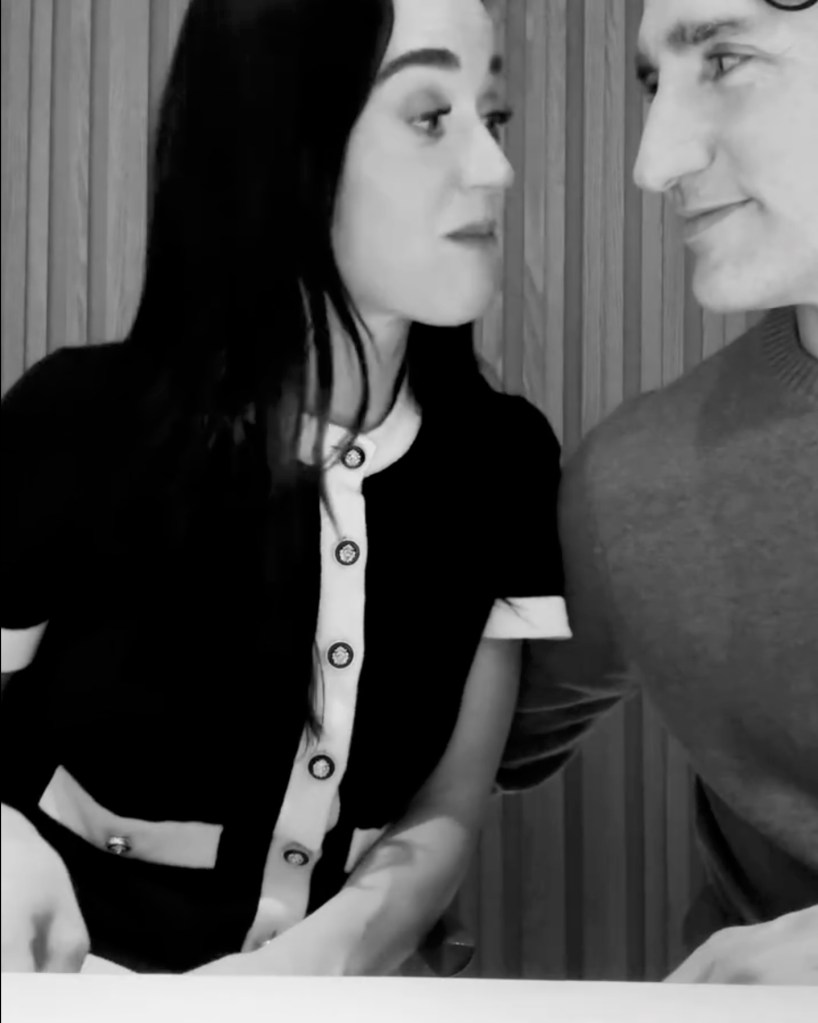 Katy Perry looking at Justin Trudeau in a black and white photo.