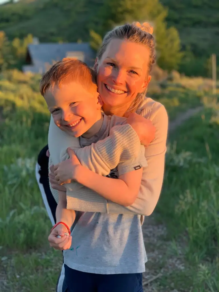 Kelley Wolf and son Miller smiling and embracing.