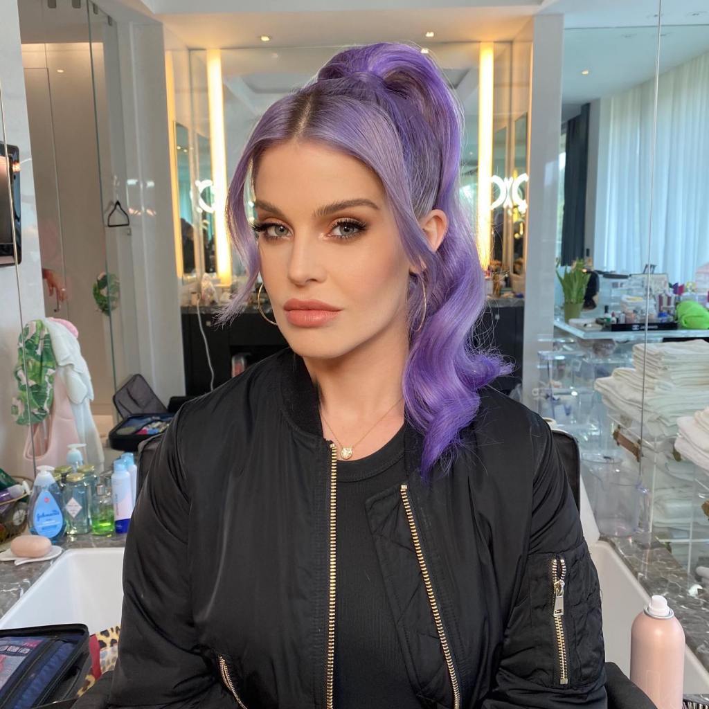 Kelly Osbourne with purple hair styled in a high ponytail.