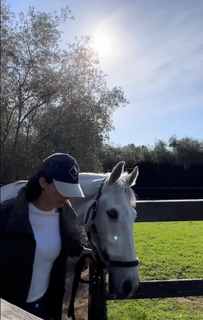 Kendall Jenner standing next to a white horse at her Montecito ranch.