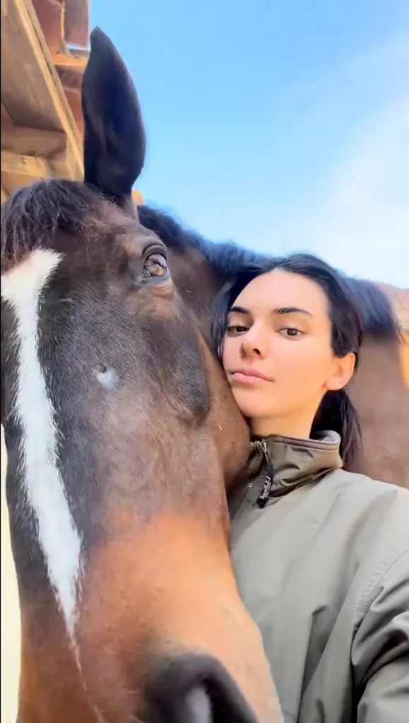 Kendall Jenner posing next to a horse.